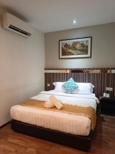 a bedroom with a bed with a towel on it at Kino Hotel in Shah Alam