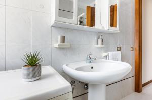 a white bathroom with a sink and a mirror at Comfortable Apartment with Parking & Terrace in Perugia