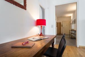 a desk with a red lamp and a book and glasses at ETATS UNIS 892 - Spacious flat on Sea front w/AC in Nice