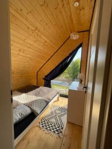 um quarto com uma cama e uma janela num quarto em Luksusowe domki Mazury em Mrągowo