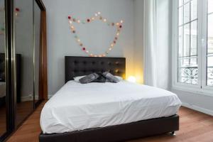a bedroom with a large white bed with a heart on the wall at ETATS UNIS 892 - Spacious flat on Sea front w/AC in Nice