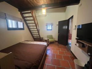 JinningにあるBlue Mountain Innのベッドと階段が備わる小さな客室です。