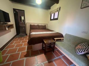 a small bedroom with a bed and a couch at Blue Mountain Inn in Jinning