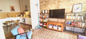 een woonkamer met een televisie en een tafel met stoelen bij Adara Vegueta Exclusive Apartment in Las Palmas de Gran Canaria