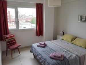 1 dormitorio con 1 cama, 1 silla y 1 ventana en Luminoso departamento de dos ambientes externo en Mar del Plata