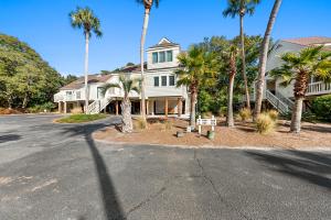 a house with palm trees in front of a street at 770 Spinnaker Beach House in Seabrook Island