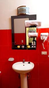 a red bathroom with a sink and a mirror at HGA-Diamante-Spa in La Paz