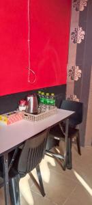 una mesa con una tetera en una pared roja en 74 Guest House Haad Rin, en Haad Rin