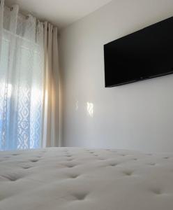 a bedroom with a flat screen tv and a bed at Hospedería Nieves Centro in Chipiona