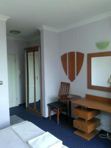 1 dormitorio con escritorio, 1 cama y espejo en Alexandrov Residence Studio en Nesebar