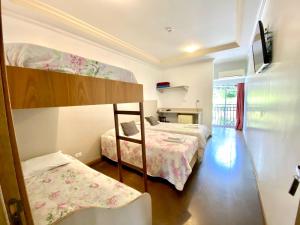 a bedroom with two bunk beds and a balcony at Pousada Primavera Campos do Jordao in Campos do Jordão