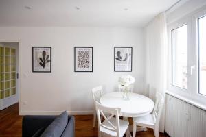 Una sala de estar blanca con una mesa y sillas blancas. en Av REPUBLIQUE Design and cozy, en Aubervilliers