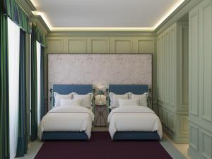 two beds in a room with green walls and windows at Room Mate Isabella in Florence