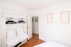 Habitación blanca con cama y sofá blanco en Av REPUBLIQUE Design and cozy, en Aubervilliers