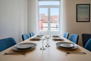 einen Esstisch mit Gläsern und Tellern sowie ein Fenster in der Unterkunft 3-bedroom 3 bathrooms renovated in 2023 in Tourcoing