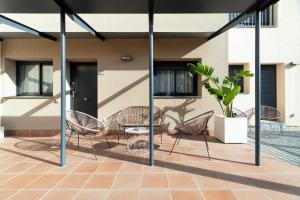 a group of chairs and a table on a patio at Castell Beach Aparthotel in Castelldefels