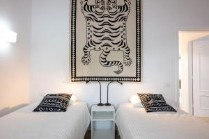 two beds in a room with a picture on the wall at Calala House with huge terrace in Candelaria