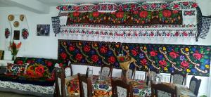 ein Zimmer mit einem Bett mit bunten Decken darauf in der Unterkunft Casa Pintea de Sub Coastă in Breb