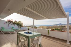 a patio with a table and chairs and a view at Calala House with huge terrace in Candelaria