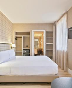 a bedroom with a large white bed and shelves at Acta CITY47 in Barcelona