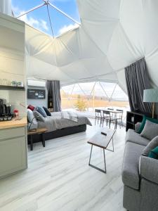 a living room with a bed and a tent at Port Wade Glamping Domes in Victoria Beach 