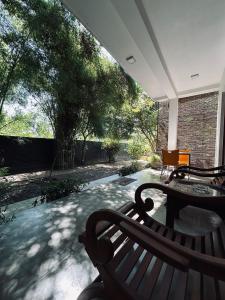 um alpendre com um banco, uma mesa e árvores em Green Corridor - Ahangama em Ahangama
