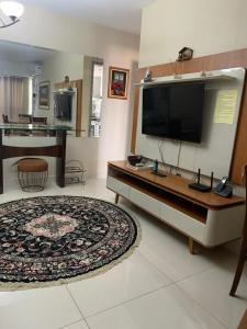 een woonkamer met een grote flatscreen-tv bij Apto com conforto que você precisa. in Goiânia