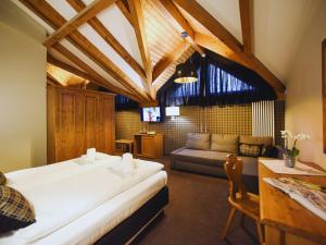 Hotel Orso Grigio في بيسكول: غرفة نوم بسرير واريكة في غرفة