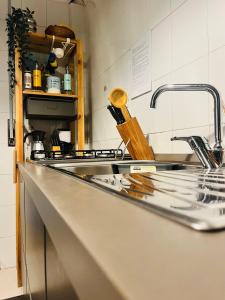 un bancone della cucina con lavandino in acciaio inossidabile e lavandino di b&b A Casa Nostra a Roma