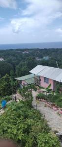 a pink building with a roof on a hill at Backra`s Villa in Port Antonio