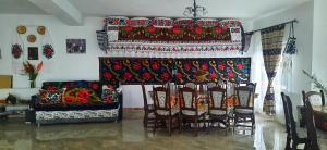 Casa Pintea de Sub Coastă في Breb: غرفة بها موقد مع طاولة وكراسي