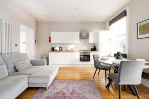 a living room with a couch and a table at Stylish & Modern London Apartment in Honor Oak in London