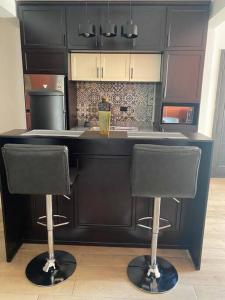 a kitchen with two bar stools in front of a counter at Apartamento #10 Portal de Occidente in Quetzaltenango