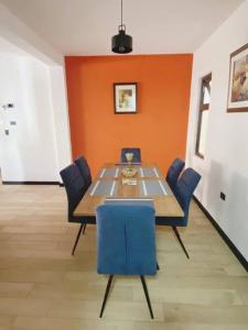 a dining room with a table and blue chairs at Apartamento #10 Portal de Occidente in Quetzaltenango