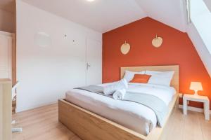 - une chambre avec un grand lit et un mur orange dans l'établissement 4 bedroom & 2 bathroom house near metro, à Tourcoing