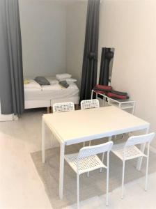 einen weißen Tisch und Stühle in einem Zimmer mit einem Schlafzimmer in der Unterkunft Moderni siisti Studio koti jossa modernit kalusteet in Helsinki
