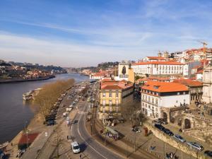 uitzicht op een stad met een rivier en gebouwen bij Memoria Porto FLH Hotels in Porto