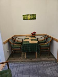 a table with four chairs and a green tablecloth on it at DanubeScree cozy Apartment in Budapest