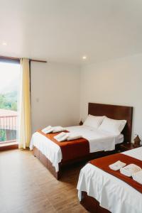 a bedroom with two beds and a large window at Donce Extremo in San Carlos