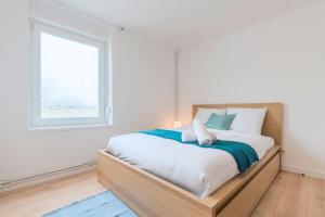 - une chambre avec un grand lit et une fenêtre dans l'établissement 4 bedroom & 2 bathroom house near metro, à Tourcoing