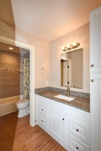 ein Badezimmer mit einem Waschbecken, einem WC und einem Spiegel in der Unterkunft Downtown Elegance: 2-BR Home - San Angelo, Texas in San Angelo