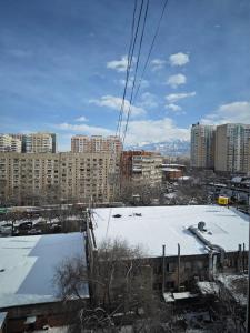 vistas a una ciudad con nieve y edificios en Green Boutique - квартира в изумрудных оттенках на Мынбаева, en Almaty