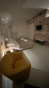 a bedroom with a bed and a yellow chair at Appartamento Pepe in Francavilla Fontana
