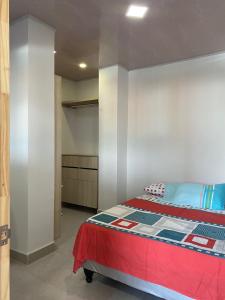 a bedroom with a bed with a red blanket at Edificio Pacifica Aptos in Cali