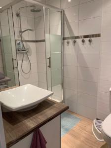 a white bathroom with a shower and a sink at la Maison d'à coté in Illkirch-Graffenstaden