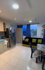 a kitchen and a living room with a couch and a table at Edificio Pacifica Aptos in Cali