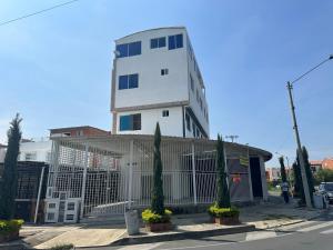 a white building with trees in front of it at Edificio Pacifica Aptos in Cali