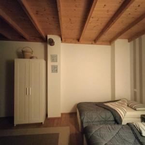 a bedroom with two beds and a cabinet in it at B&B Terre Di Bea in Pederobba