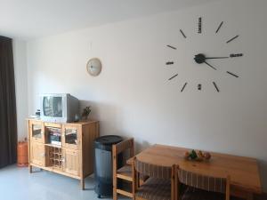 Zimmer mit einem Tisch und einer Uhr an der Wand in der Unterkunft Apartamento a pie de pistas Port del Comte in La Coma i la Pedra