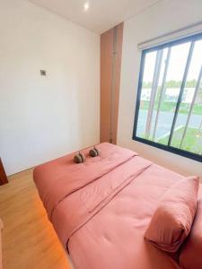 ein großes rosa Bett in einem Zimmer mit Fenster in der Unterkunft Villa Kamar Tamu Balecatur 2 in Sleman